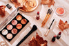 fall makeup products scattered about a white table.